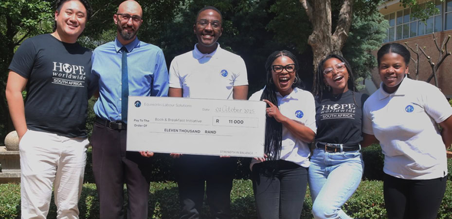 Group of diverse people holding a check for eleven thousand Rand, supporting Hope Worldwide South Africa.