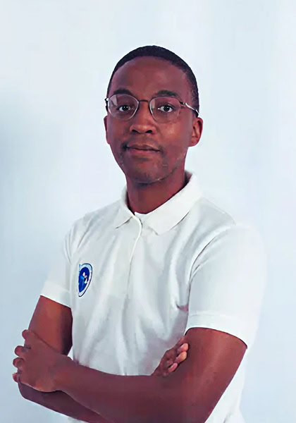 Portrait of a confident Black man wearing glasses and a white polo shirt with arms crossed, showcasing a professional look.