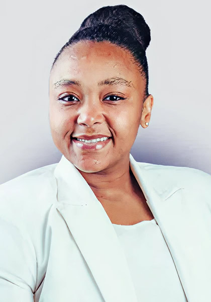 Professional headshot of a smiling Black woman in a white blazer. Business portrait with elegant hairstyle.