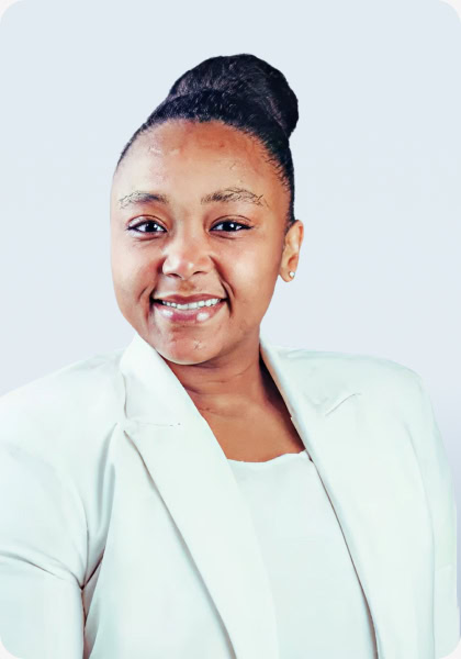 Woman smiles wearing a white blazer and top with her hair in a bun.